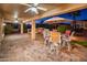 Outdoor patio featuring brick flooring, an umbrella-covered table with seating, and a cozy fireplace at 12936 W Sola Dr, Sun City West, AZ 85375