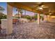 Inviting covered patio featuring a stone fireplace, seating area, and well-manicured landscaping at 12936 W Sola Dr, Sun City West, AZ 85375