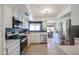 Bright kitchen features stainless steel appliances, white cabinetry, and tiled floor at 13232 W Ballad Dr, Sun City West, AZ 85375