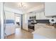 Bright kitchen features stainless steel appliances, white cabinetry, and tiled floor at 13232 W Ballad Dr, Sun City West, AZ 85375