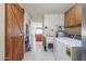 Functional laundry room with a rustic barn door and modern appliances, blending style with utility at 13232 W Ballad Dr, Sun City West, AZ 85375