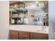 Wet bar featuring wooden cabinets, a sink, and mirrored shelves for glassware display at 13232 W Ballad Dr, Sun City West, AZ 85375