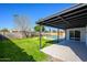 A covered patio enhances the backyard, overlooking a lush lawn and a sparkling in-ground pool at 13446 N 18Th Ave, Phoenix, AZ 85029