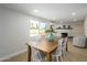 Dining area with a large wooden table, white chairs, and bright backyard view at 13446 N 18Th Ave, Phoenix, AZ 85029