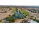 Aerial view showcasing neighborhood pond with a small island and palm tree surrounded by mature landscaping at 14264 S Baniff Ln, Arizona City, AZ 85123