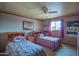 Cozy bedroom with two twin beds, ceiling fan, and soft lighting at 14264 S Baniff Ln, Arizona City, AZ 85123