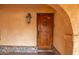 Elegant wood front door with decorative ironwork and a charming exterior light fixture at 14264 S Baniff Ln, Arizona City, AZ 85123