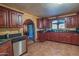 Well-appointed kitchen with cherry wood cabinetry, dark countertops, and stainless steel appliances at 14264 S Baniff Ln, Arizona City, AZ 85123