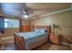 Comfortable main bedroom features a ceiling fan, wood flooring, and natural light at 14264 S Baniff Ln, Arizona City, AZ 85123