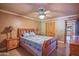 Comfortable main bedroom features a ceiling fan, wood flooring, and natural light at 14264 S Baniff Ln, Arizona City, AZ 85123