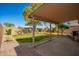 A covered patio extends into a grassy, private, fenced-in backyard at 14946 W Caribbean Ln, Surprise, AZ 85379