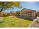 Expansive backyard featuring a well-maintained lawn, mature tree, and covered patio area at 14946 W Caribbean Ln, Surprise, AZ 85379