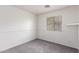 The neutral bedroom features a large window and plush carpet at 14946 W Caribbean Ln, Surprise, AZ 85379