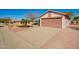 Exterior shot of a single-story home with a two-car garage and desert landscaping at 14946 W Caribbean Ln, Surprise, AZ 85379