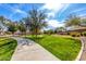 Scenic community park featuring lush green grass, walking paths, mature trees, and beautiful blue skies at 16150 W Hope Dr, Surprise, AZ 85379