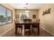 Cozy dining area with a wood table, window with blinds, and tile flooring at 16150 W Hope Dr, Surprise, AZ 85379