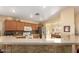 Open kitchen with wood cabinets, stainless steel refrigerator, and a breakfast bar at 16150 W Hope Dr, Surprise, AZ 85379