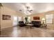 Bright and airy living room with tile floors, ceiling fan, and access to the outdoors through glass doors at 16150 W Hope Dr, Surprise, AZ 85379