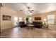 Bright and airy living room with tile floors, ceiling fan, and access to the outdoors through glass doors at 16150 W Hope Dr, Surprise, AZ 85379