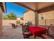 Covered patio features a table with red tablecloth, chairs, and barbeque grill perfect for outdoor living at 16150 W Hope Dr, Surprise, AZ 85379