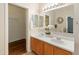 Bathroom with double sinks, a large mirror, and modern fixtures at 16219 W Woodlands Ave, Goodyear, AZ 85338