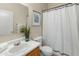 Bright bathroom featuring a white vanity, white toilet, and a shower with a stylish curtain at 16219 W Woodlands Ave, Goodyear, AZ 85338