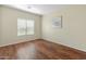 Cozy bedroom with a window, neutral paint and laminate flooring at 16219 W Woodlands Ave, Goodyear, AZ 85338