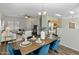 Open concept dining room with a wood table, blue chairs, and views into the living room and kitchen at 16219 W Woodlands Ave, Goodyear, AZ 85338