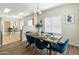 Dining room with a dark wood table, blue chairs, and views into the kitchen and second dining area at 16219 W Woodlands Ave, Goodyear, AZ 85338