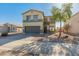 Two story home with a desert landscaped front yard and a two car garage in a sunny environment at 16219 W Woodlands Ave, Goodyear, AZ 85338