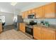 Well lit kitchen with oak cabinets, stainless appliances, granite countertops, and tile floors at 16219 W Woodlands Ave, Goodyear, AZ 85338