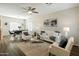 Cozy living room with wood floors, a ceiling fan, white furniture and lots of natural light at 16219 W Woodlands Ave, Goodyear, AZ 85338