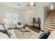 Comfortable living room featuring stairs, hardwood floors, a ceiling fan and white furniture at 16219 W Woodlands Ave, Goodyear, AZ 85338