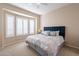 Comfortable bedroom featuring a bay window with plantation shutters and stylish blue headboard with decorative pillows at 16420 N Thompson Peak Pkwy # 2120, Scottsdale, AZ 85260