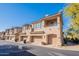 Exterior view of a multi-story townhome with a balcony, arched entryway, and attached garage, set against a blue sky at 16420 N Thompson Peak Pkwy # 2120, Scottsdale, AZ 85260