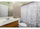 Bathroom features a tiled shower with patterned curtain, updated toilet, and vanity sink at 16528 W Pierce St, Goodyear, AZ 85338