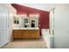 Bathroom with double vanity, large mirror, bathtub, walk-in shower, and red accent wall at 16528 W Pierce St, Goodyear, AZ 85338