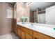 Well-lit bathroom featuring a vanity with a white countertop, light wood cabinets, and a large mirror at 16528 W Pierce St, Goodyear, AZ 85338