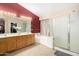 Bathroom featuring a vanity with dual sinks, a shower, and soaking tub at 16528 W Pierce St, Goodyear, AZ 85338