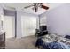 Bedroom with ceiling fan, light purple walls, computer desk, and carpeted floor at 16528 W Pierce St, Goodyear, AZ 85338