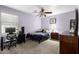 Comfortable bedroom with ceiling fan, window, desk area and dark wood dresser at 16528 W Pierce St, Goodyear, AZ 85338