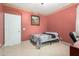 Cozy bedroom features tiled floors, a decorative accent wall, and a door to an ensuite bathroom at 16528 W Pierce St, Goodyear, AZ 85338