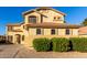 Two-story stucco home with a tile roof, arched windows, and lush, flowering bushes in the front yard at 16528 W Pierce St, Goodyear, AZ 85338