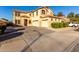 A sunny day showing a spacious two-story home with a three-car garage and landscaped front yard at 16528 W Pierce St, Goodyear, AZ 85338