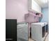 Bright laundry room with a modern washer and dryer set and overhead white storage cabinets at 16528 W Pierce St, Goodyear, AZ 85338