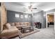 Comfortable living room with a large sectional sofa, a ceiling fan, and neutral decor at 16528 W Pierce St, Goodyear, AZ 85338