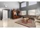 Bright living room featuring high ceilings, tile flooring, and a large entertainment center at 16528 W Pierce St, Goodyear, AZ 85338