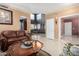 Spacious living room with tile floors, leather furniture, and an open doorway to another living space at 16528 W Pierce St, Goodyear, AZ 85338