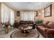 Cozy living room with brown leather sofas, ornate details, and natural lighting at 16528 W Pierce St, Goodyear, AZ 85338