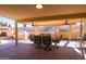 Covered patio featuring a large dining table, ceiling fans, and stone fireplace at 17217 E Calaveras Ave, Fountain Hills, AZ 85268